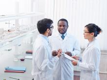 Three whitecoats in lab talking.